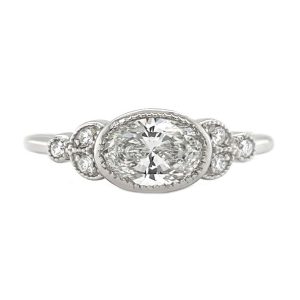 Classic art deco style ring oval shape cut diamond centre stone millgrain round diamonds shoulders setting engagement platinum gold